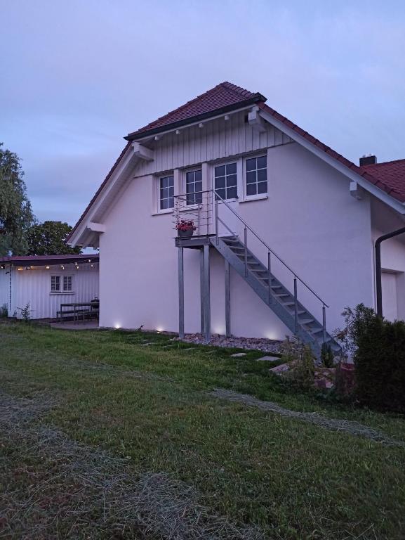 a white house with a staircase on the side of it at Ferienwohnung Reichenbach in Bad Schussenried