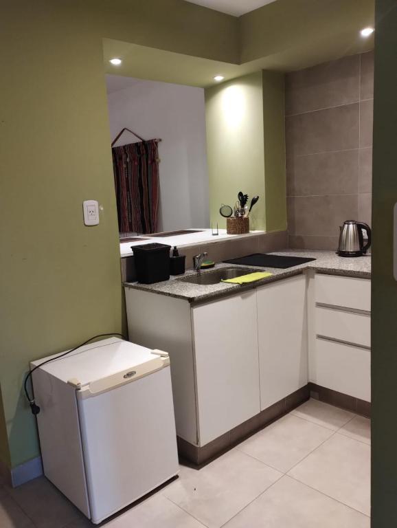 a kitchen with white cabinets and a counter top at JAZCA Huayco in San Salvador de Jujuy