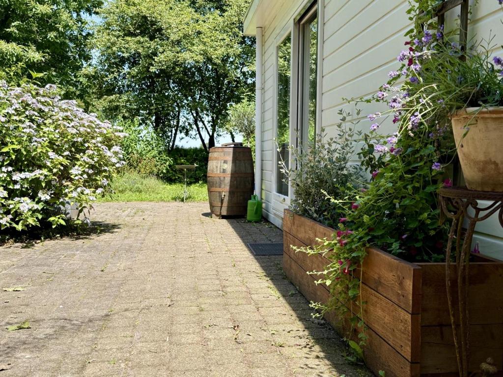 a house with flowers and barrels on the side of it at Villaatje Veluwe in Garderen