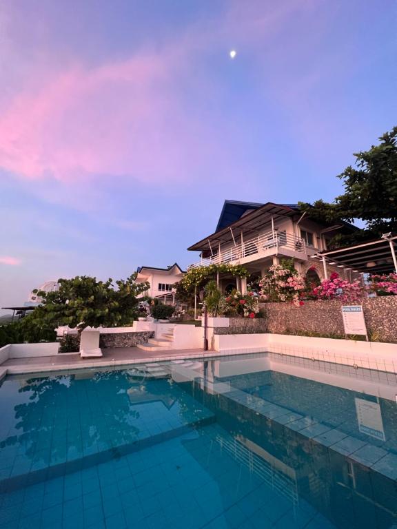 a swimming pool in front of a house at Oceano con Vista Mountain Resort in Tagbaobo