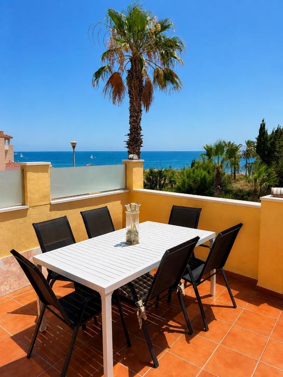 a table and chairs on a balcony with a palm tree at Amazing view bungalow MA2 in Torrevieja