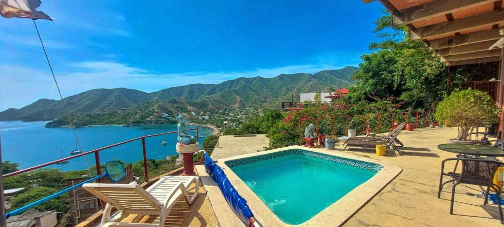 a swimming pool with chairs and a view of the water at Mar en Casa - Taganga - Vista al Mar in Taganga