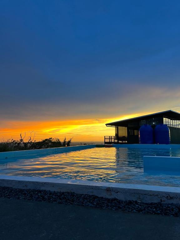 a swimming pool with a sunset in the background at Finca Mirador De Gualaca in Gualaca