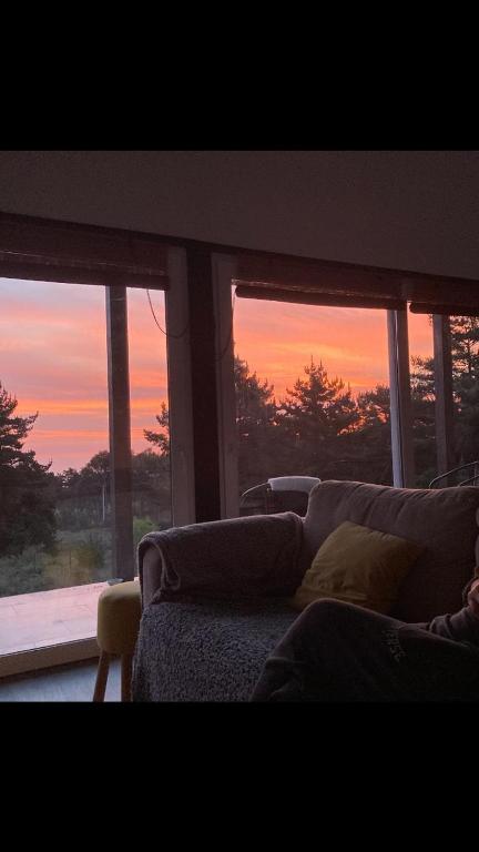 a living room with a couch and a sunset at Casa acogedora a pasos de la playa in Guaquen