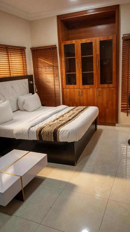 a bedroom with a large bed and a table at Posh Hotelia in Hausa