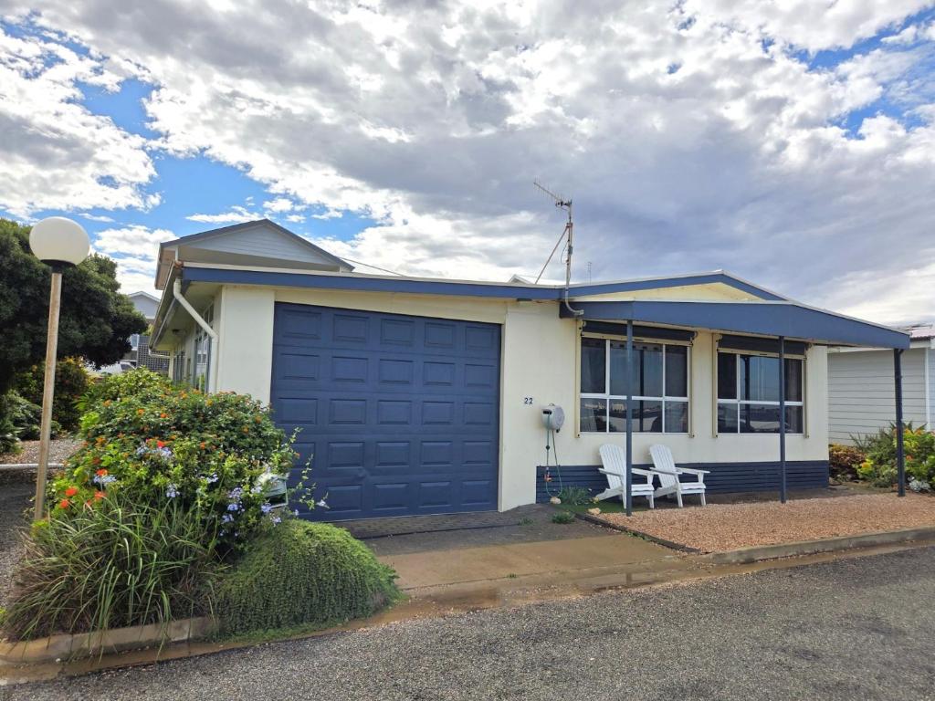 a house with a blue garage door on a street at Dolphin Cove in Wallaroo