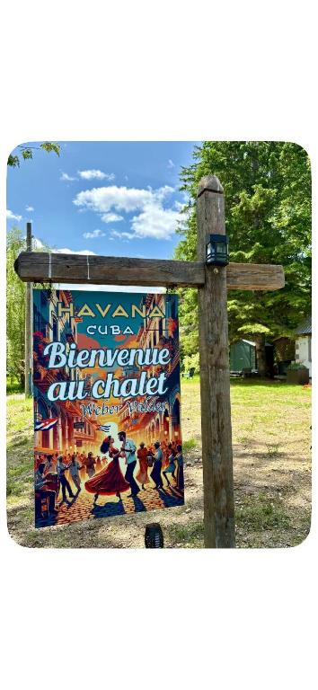 a sign on a wooden post with a poster at Chalet Havana in Namur