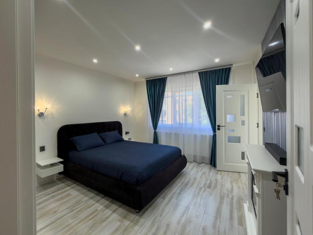 a bedroom with a blue bed and a desk at Luu's Studio! in Hunedoara