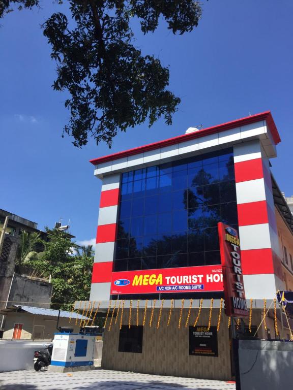 a mexican tourist hotel with a red and white building at Mega Tourist Home in Guruvāyūr