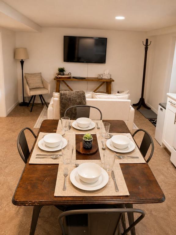 a wooden table with plates and glasses on it in a living room at The Bunny Street Getaway! in Kenora