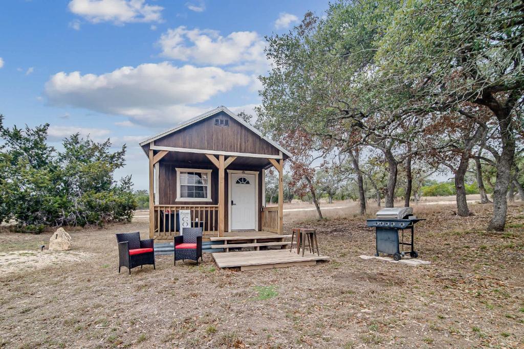 a tiny house with a picnic table and chairs at Hill Country Cabin 1 in Canyon Lake