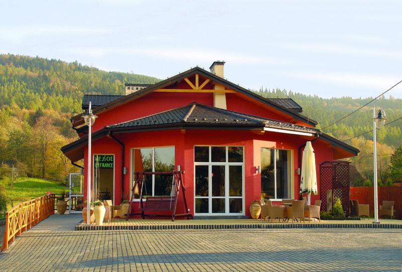 a red building with two dogs in front of it at Hotel Krak in Myślenice