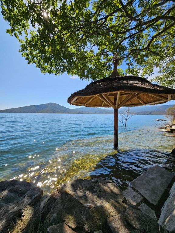 an umbrella sitting in the water next to a lake at Velas del Lago in Piedras Moradas