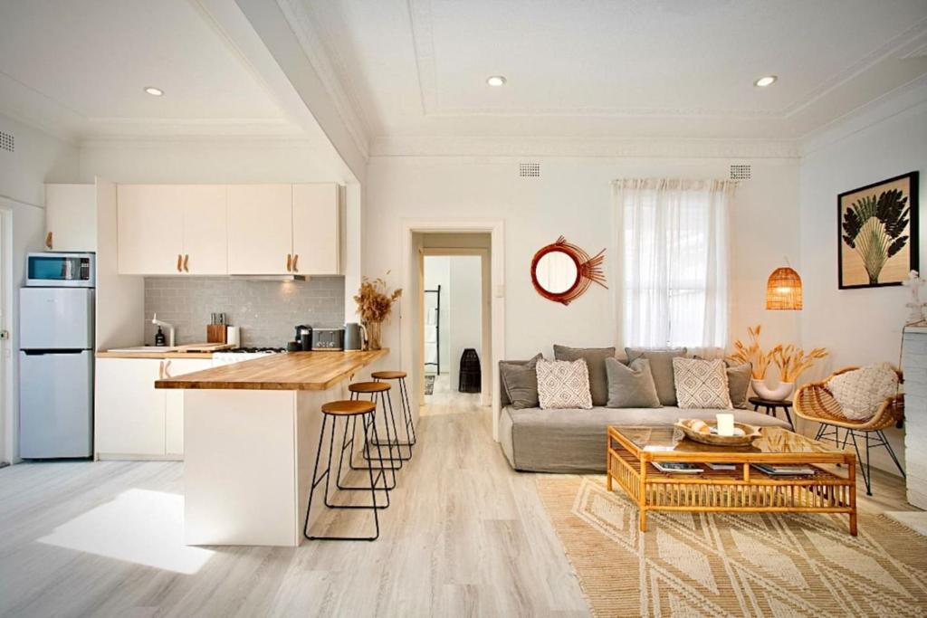 a kitchen and living room with a couch and a table at Bondi Surf Cottage in Sydney