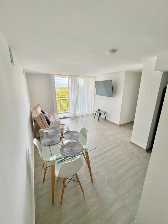 a living room with a table and chairs and a tv at Apartamento modero nuevo, 3 habitaciones y parqueadero en conjunto in Neiva