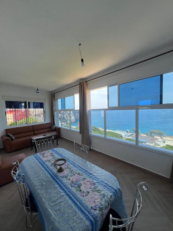 a living room with a table and a view of the ocean at La Vista Azul in Belyounech 