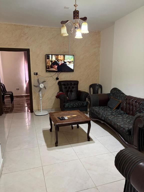 a living room with couches and a coffee table at الشقة العائلية الحديثة familial new flat in Amman