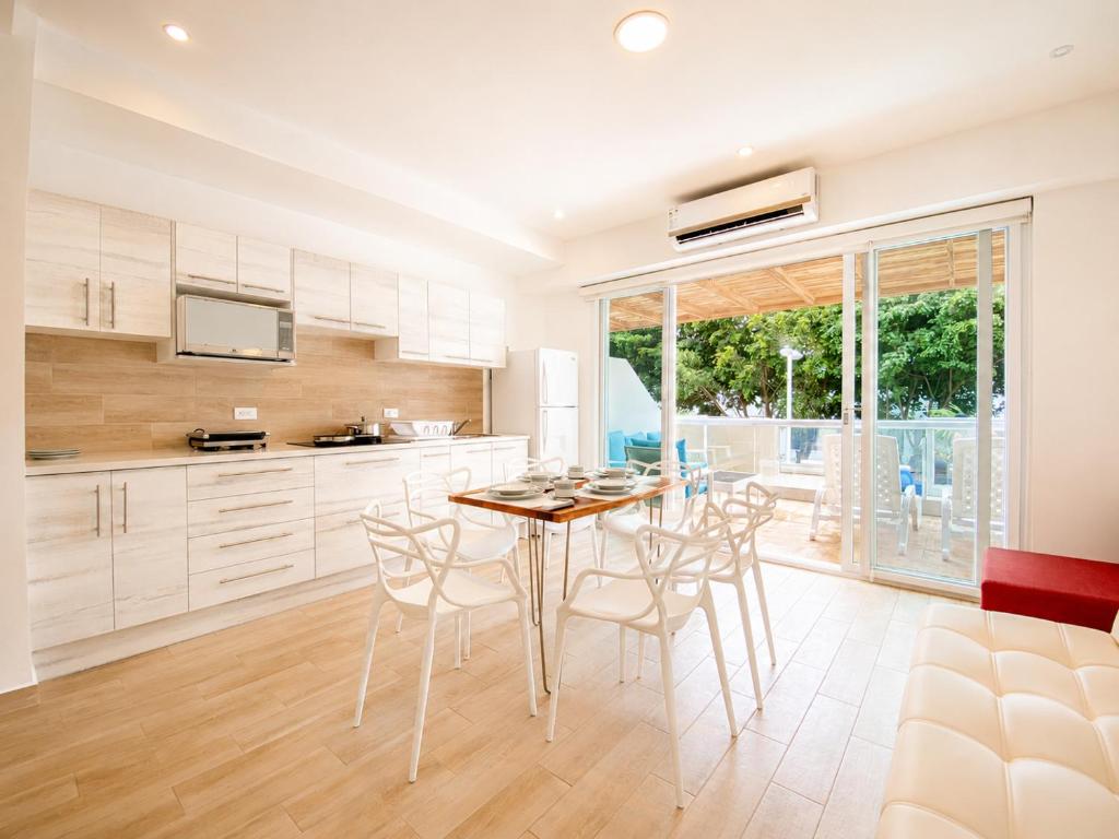 a kitchen and dining room with a table and chairs at Playa Azul Exclusive Suites in Tonsupa