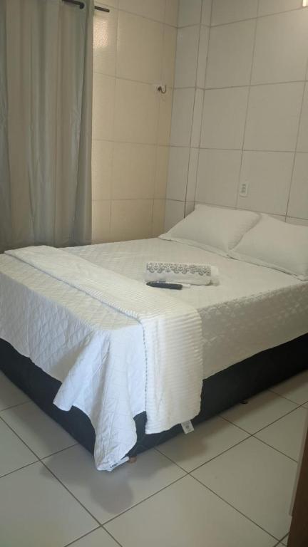 a bed with a white blanket on top of it at Apartamento aconchegante in Marabá