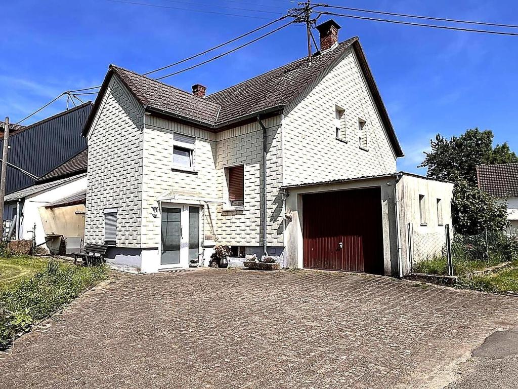 a white house with a garage on a driveway at Holiday Home in Badem in Badem