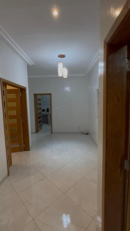 an empty room with white walls and a large tile floor at La résidence des lions in Thiès
