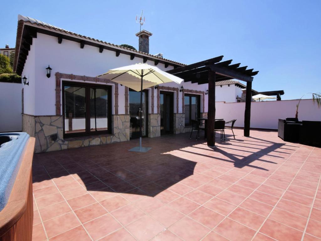 a patio with an umbrella in front of a house at Beautiful villa with jacuzzi in Canillas de Albaida