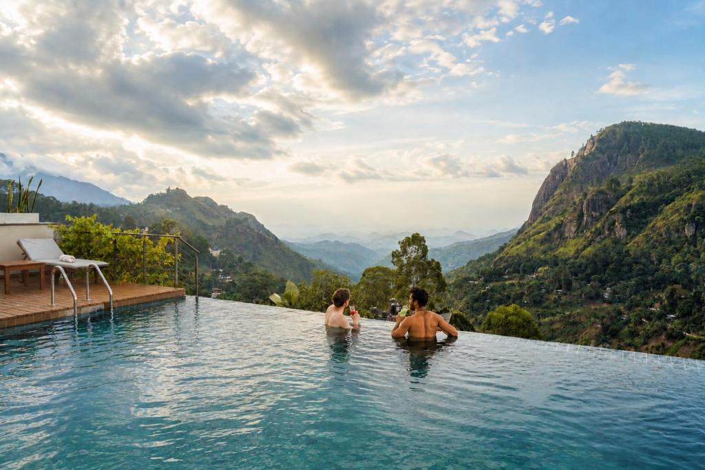 zwei Personen in einem Infinity-Pool in den Bergen in der Unterkunft Onrock Boutique Hotel in Ella