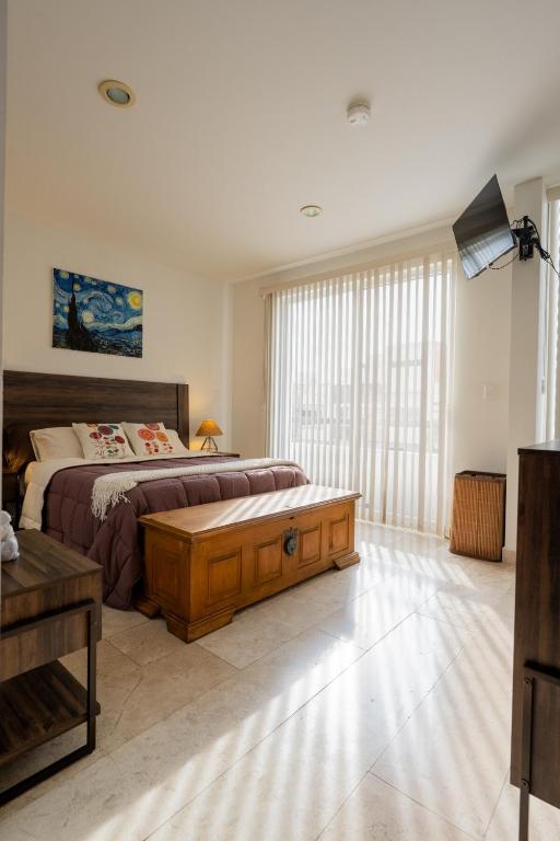 a bedroom with a large bed and a large window at Días tranquilos dentro de El Refugio in San José el Alto