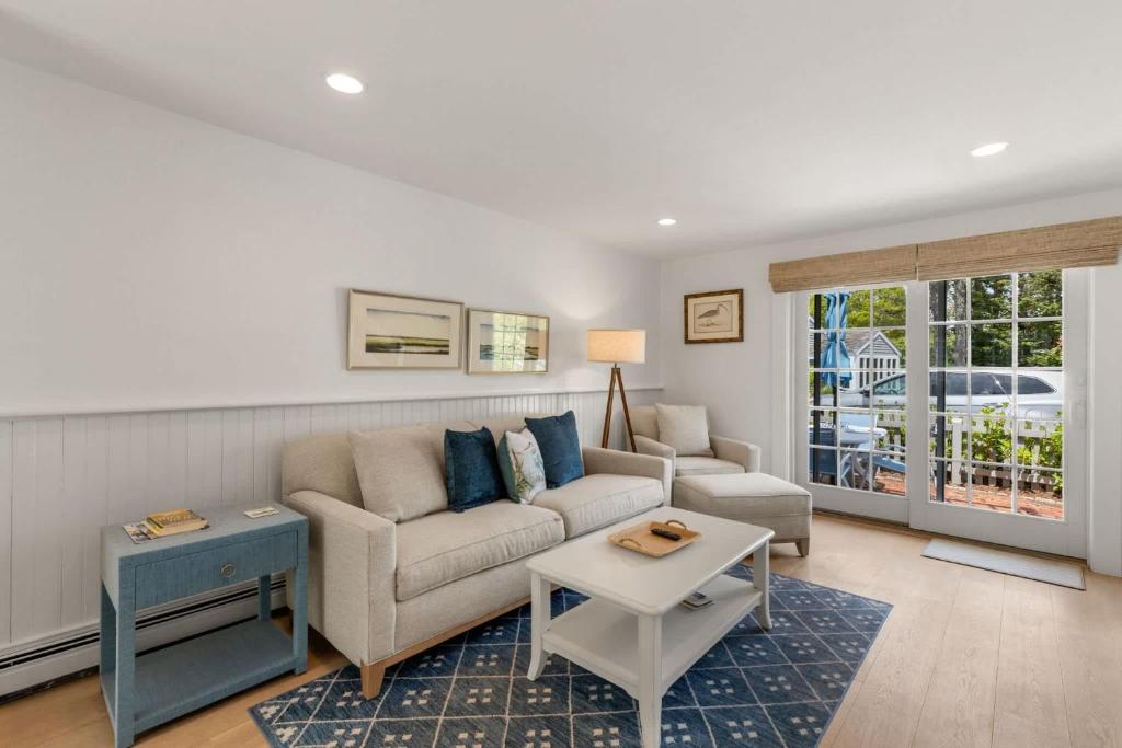 a living room with a couch and a table at Hydrangea Lane Beach Cottage in Mashpee