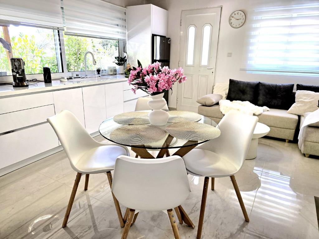 a kitchen and living room with a glass table and white chairs at Ktima Voulme in Kavála
