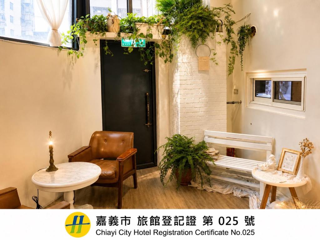 a room with a black door and a chair and a table at Prince Hotel in Chiayi City