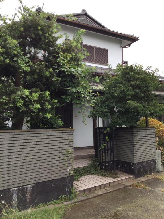 a house with a gate and trees in front of it at いちご荘 in Ichihara