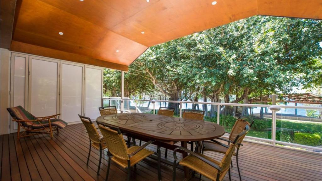 a wooden deck with a table and chairs on it at Picnic Bay Apt 3. in Picnic Bay