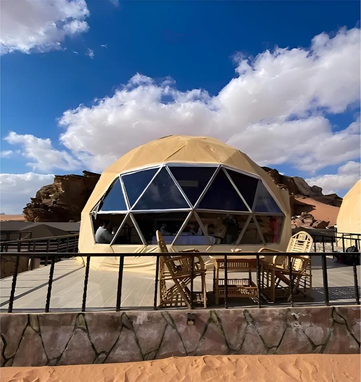 a yurt in the desert with tables and chairs at Moonlight Luxury Bubble Camp & Jeep Tours in Wadi Rum