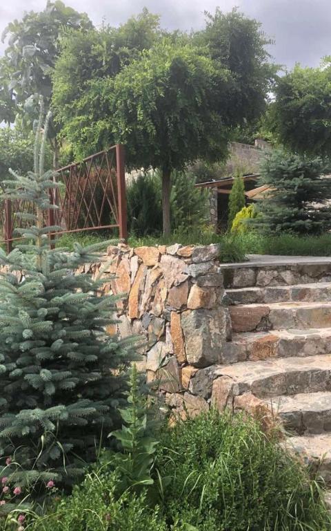 a stone retaining wall and stairs in a garden at Villa Maria Dilijan in Dilijan