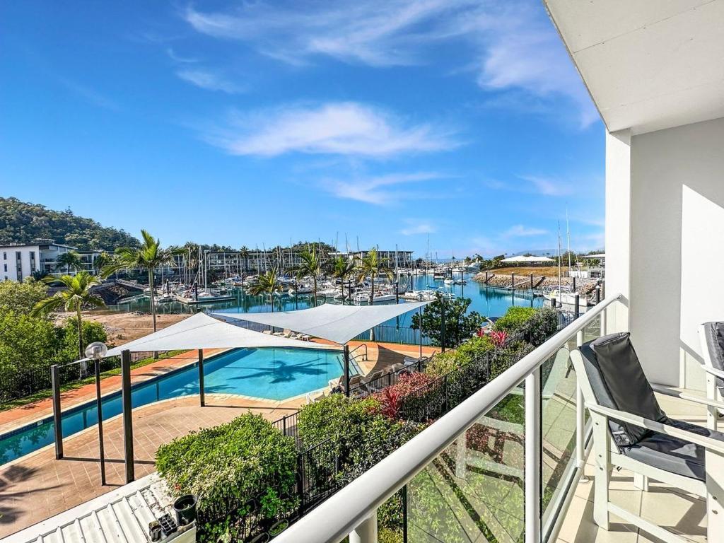 a balcony with a view of a swimming pool at Beachside 17 in Nelly Bay