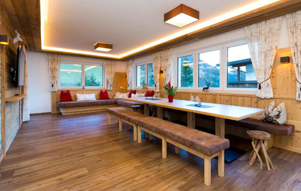 a large living room with a large table and benches at Ferienhaus Alpenherz in Finkenberg