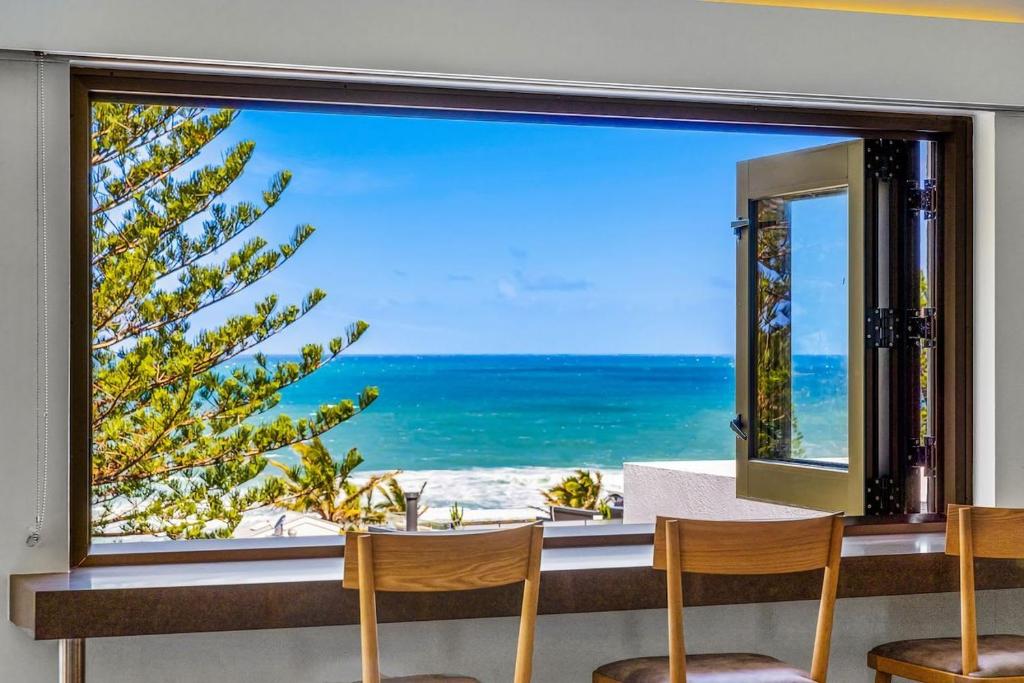 a large window with a view of the ocean at Salt Luxury Location in Sunshine Beach