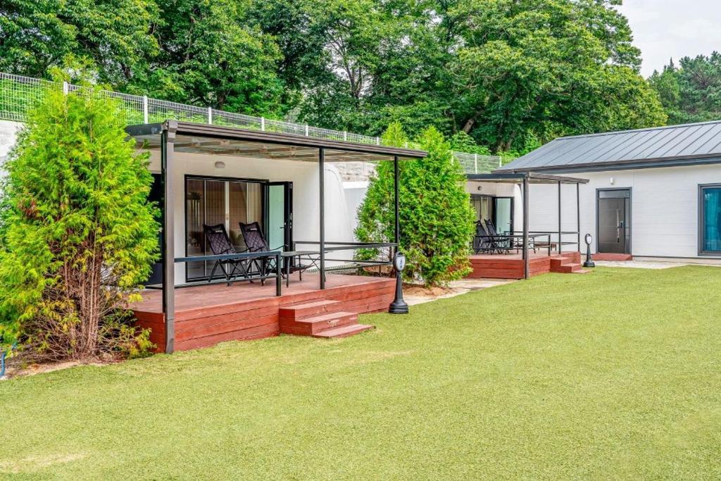 a home with a porch with chairs on it at The Cliff Caravan Camping in Pocheon