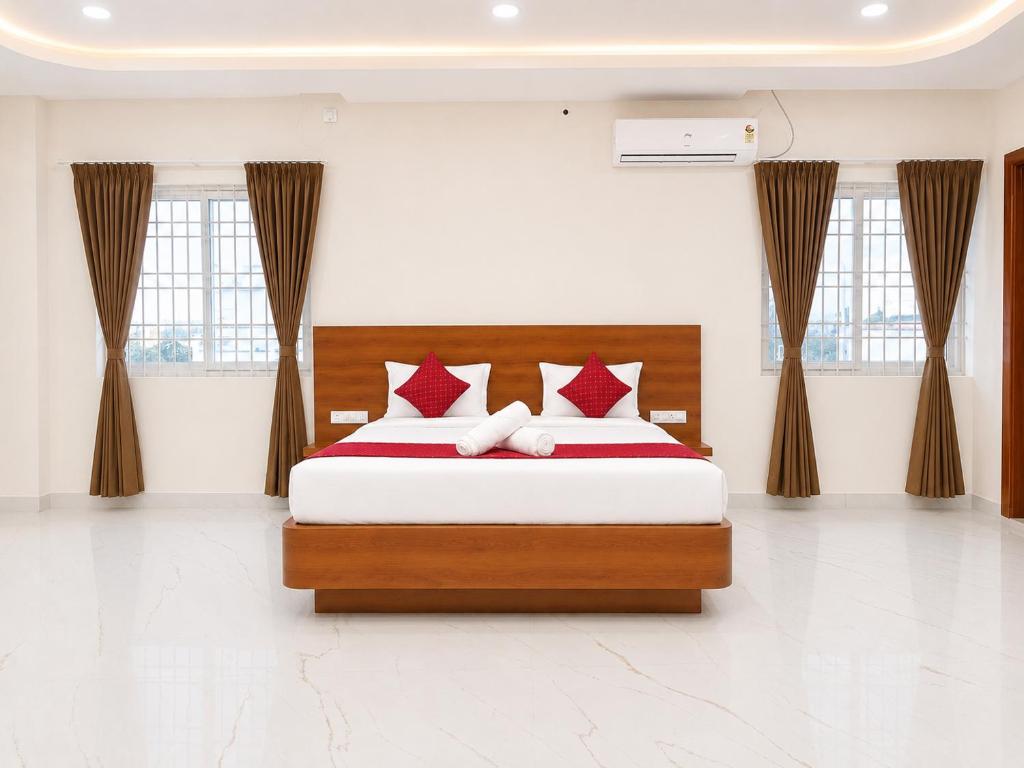 a bedroom with a bed with red and white pillows at K V Comforts in Chikmagalūr