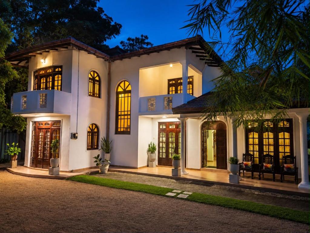 a large white house with a lot of windows at Deke Kanuwa in Kandy