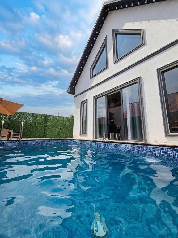 a swimming pool in front of a house at A-frame-WHITE HOUSE-II in Qusar