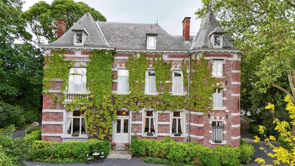 an old brick house covered in ivy at Le Jardin des Roses Mons & Pairi Daiza proches in Dour