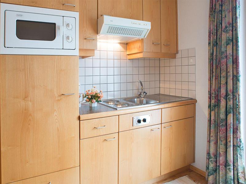 a small kitchen with a sink and a microwave at Edelweiss 101 - Typ B in Fontanella