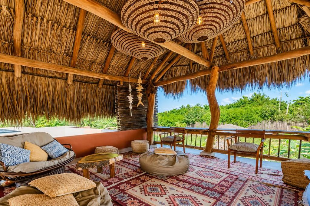 a living room with a couch and chairs in a hut at Las Dunas Beach house en Santa veronica cerca a la playa in Juan de Acosta