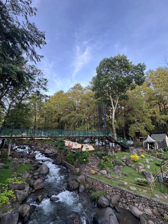 a bridge over a river with at Jolotundo Glamping and Edupark in Sagi