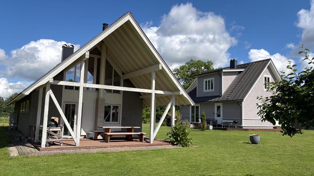 a large white house with a picnic table on a lawn at Sportsmen´s Holiday House in Otepää