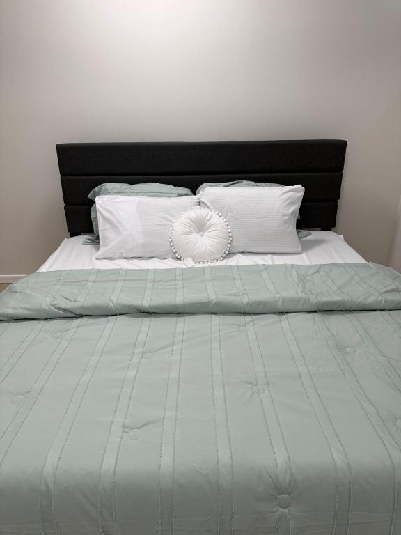 a bed with white pillows and a black headboard at Dans luxury suite in Winnipeg