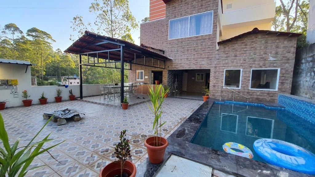 a house with a swimming pool in the backyard at Grandwood Coco Resort Yercaud in Yercaud