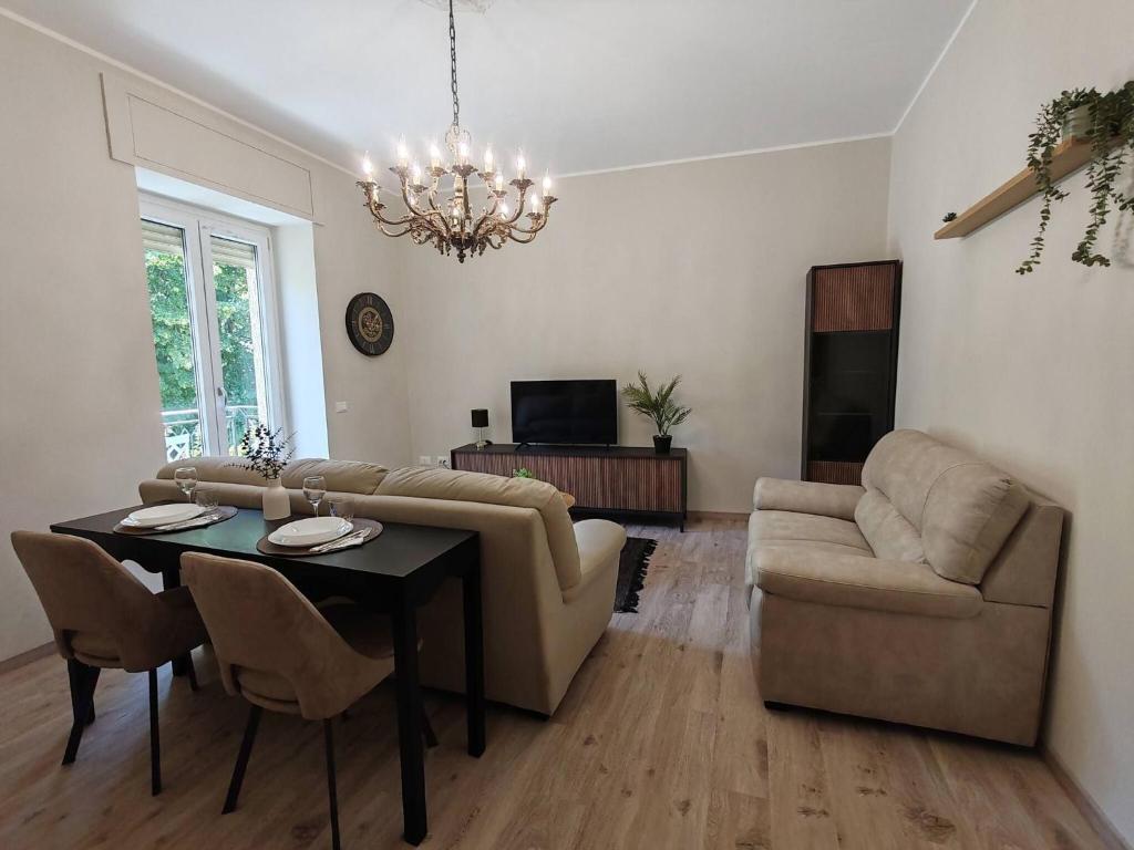 a living room with a couch and a table and a chandelier at Cozy apartment overlooking the main square in Orsogna
